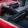 ADAPT Gullwing Truck Bed Tool Box installed in the bed of a red pickup with hand tools, wrenches, and sockets neatly organized inside
