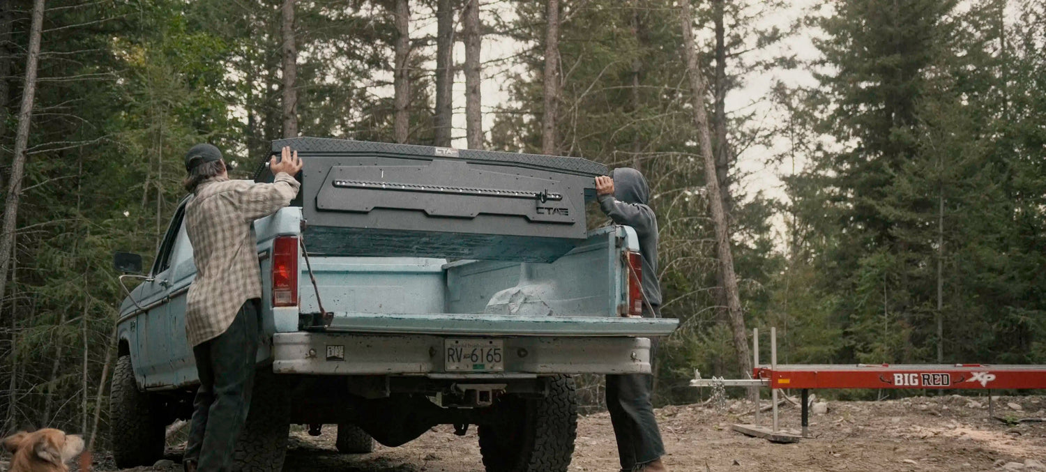 Two people talking as they're installing an ADAPT truck tool box into the bed of an old Ford pickup | Chandler Truck Accessories Blog