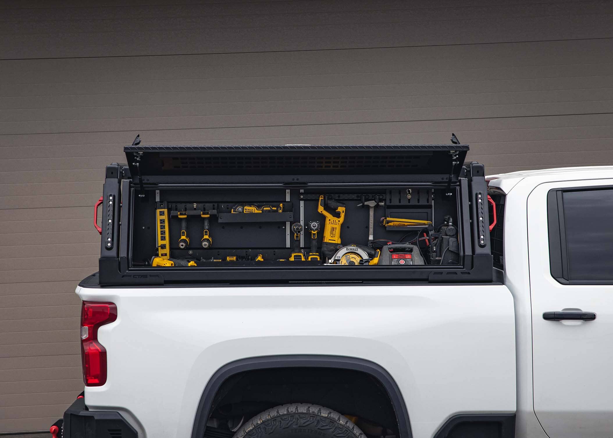 ADAPT Top Side Truck Toolbox Storage Chandler Truck Accessories. A picture of a heavy duty side truck tool box truck that is open. It appears the large weather proof truck tool box is very durable and can hold many tools. Inside the truck tool box are various tools used in construction.